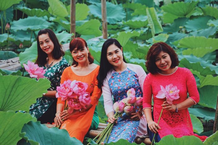 đến các cô trung niên cũng xúng xính trong những tà áo dài thướt tha cùng những bông sen nở rực rỡ