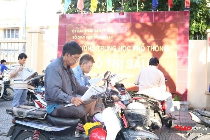 Những phụ huynh lớn tuổi chăm chú đọc báo.