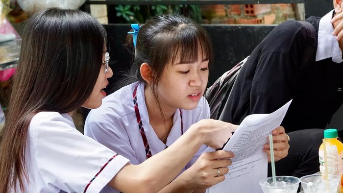 Thí sinh trao đổi sau khi kết thúc môn thi tổ hợp Khoa học tự nhiên tại điểm thi trường THPT Tân Phong, quận 7. Ảnh: HOÀNG HÙNG