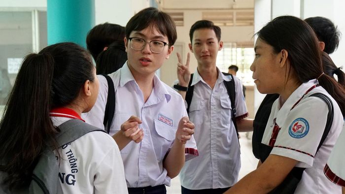Thí sinh trao đổi sau khi kết thúc môn thi tổ hợp Khoa học tự nhiên tại điểm thi trường THPT Tân Phong, quận 7. Ảnh: HOÀNG HÙNG