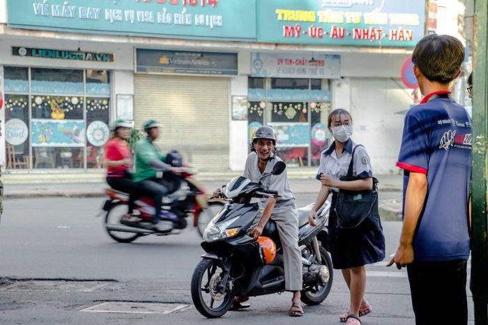 Người cha đưa con gái đến điểm thi.