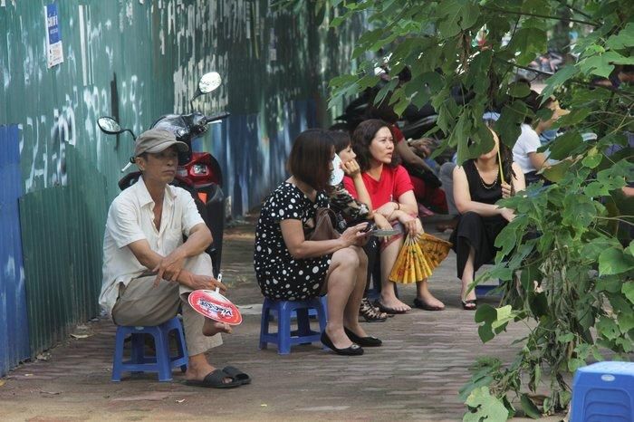 Các phụ huynh tận dụng bóng cây ngồi đợi con.