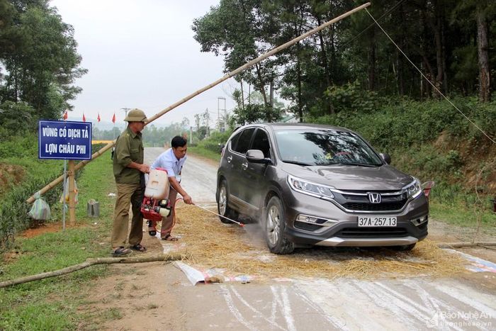 Lực lượng chức năng xã Nam Nghĩa (Nam Đàn) phun hóa chất khử trùng phương tiện ra vào địa bàn. Ảnh: Quang An