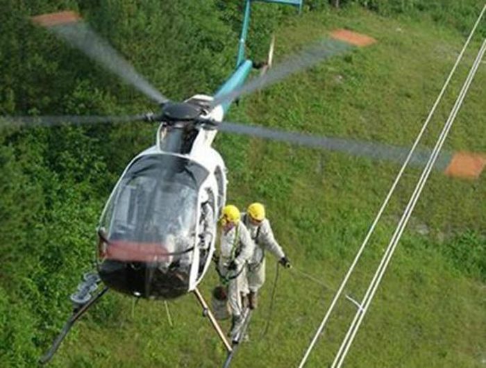  Sửa dây cáp điện từ trực thăng: Công nhân sửa dây cáp trực thăng vừa phải làm quen được với độ cao và sự lắc lư từ trên dây cáp vừa phải sửa đường dây để cung cấp điện cho thành phố. Họ được trang bị quần áo cách điện đặc biệt để làm công việc nguy hiểm này 