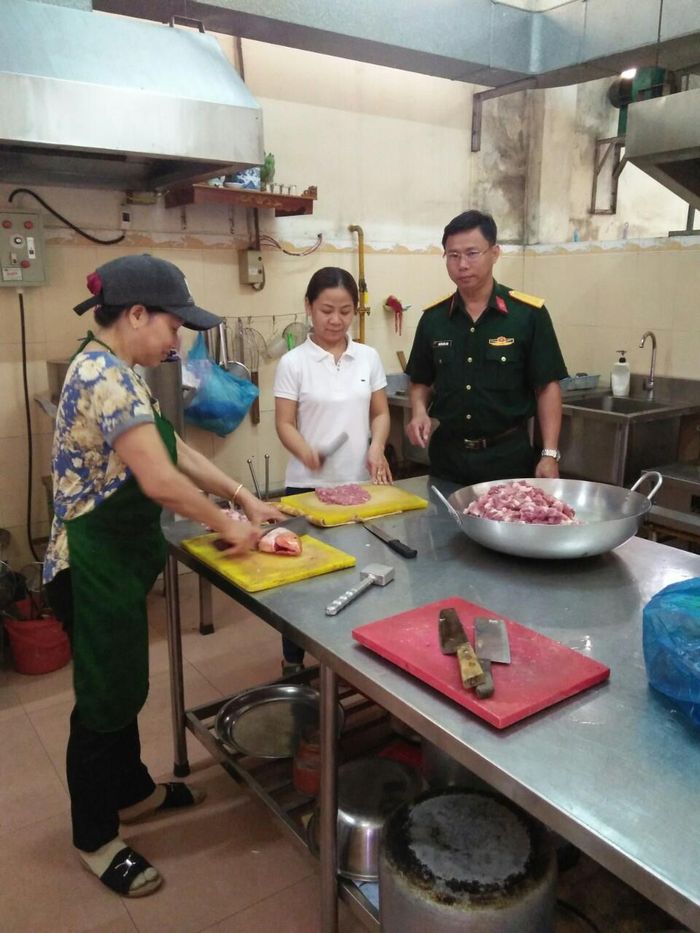Đại úy QNCN Nguyễn Đức Lanh hướng dẫn bộ phận nuôi quân chế biến món ăn.