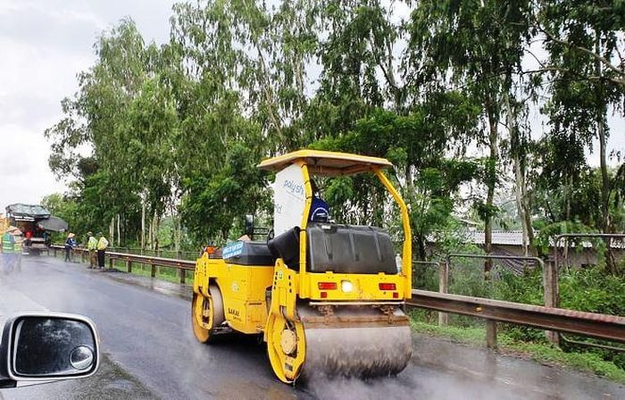 Trong điều kiện thời tiết mưa, việc rải thảm nhựa, dùng xe lu mặt đường vẫn được tiến hành trên tuyến cao tốc Hà Nội - Thái Nguyên