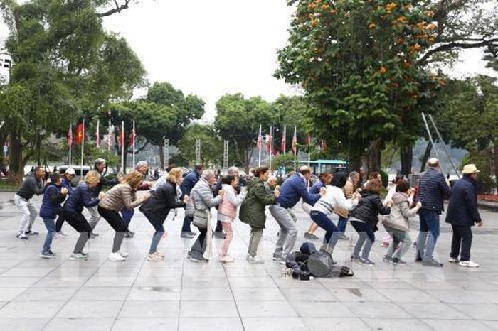 Hà Nội là thành phố bình yên, có sức hấp dẫn lớn đối với du khách, các nhà đầu tư và khách quốc tế không chỉ bởi cảnh đẹp và bề dày văn hóa truyền thống, mà còn ở sự an toàn tuyệt đối, sự thân thiện, hiếu khách của người dân Thủ đô. Trong ảnh: Đoàn khách du lịch quốc tế cùng tập thể dục với người dân Thủ đô tại khu vực vườn hoa Lý Thái Tổ bên hồ Hoàn Kiếm. Ảnh: Minh Quyết – TTXVN