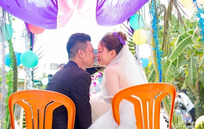 Ngồi trên xe bò với 2 chiếc ghế nhựa lúc lắc, chú rể và cô dâu "tranh thủ" thể hiện tình cảm yêu thương.