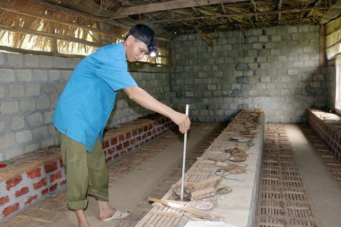 Anh Đoàn Văn Ưởng cho rắn ăn bằng dụng cụ tự chế.
