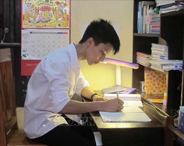 Em Bùi Văn Long học bài ở nhà. Ảnh: Thùy Dung/TTXVN