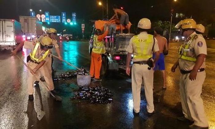 Các chiến sĩ CSGT hỗ trợ thu gom chai bia đổ vỡ