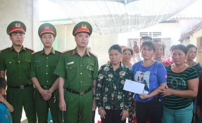 Đại diện Lãnh đạo Phòng Cảnh sát hình sự Công an Nghệ An bàn giao chị Lan và trao phần quà cho gia đình.