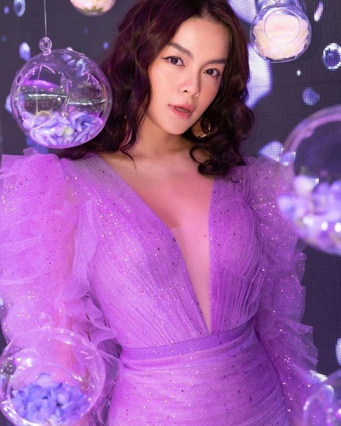 Ca sĩ Phạm Quỳnh Anh ngọt ngào và quyến rũ trong thiết kế sắc tím mộng mơ. Chi tiết xẻ ngực, cầu tay xếp nếp một cách lạ mắt khiến bà mẹ 2 con trở nên thu hút trong mắt người đối diện. 