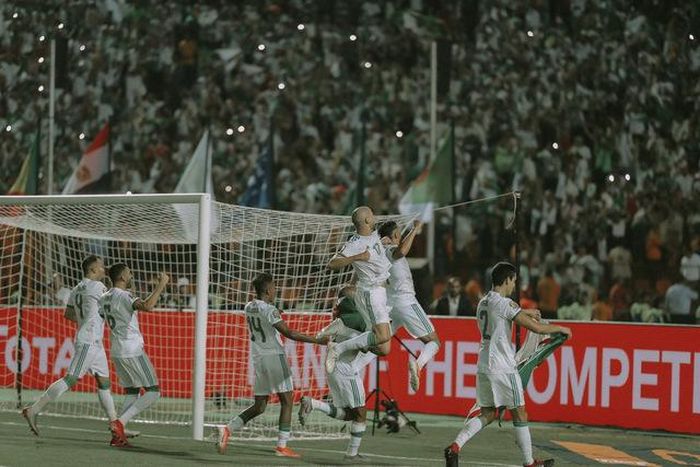 Các cầu thủ Algeria ăn mừng chiến thắng sau trận chung kết với khán giả có mặt trên sân Cairo.