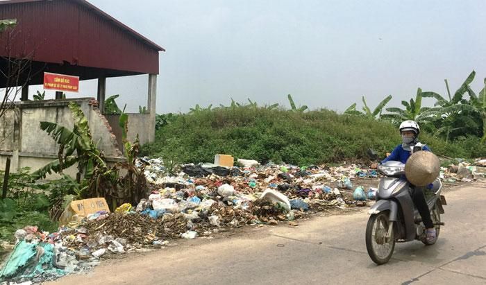 Rác thải ùn ứ tại khu vực tập kết ven đường giao thông liên xã Xuân Phú, huyện Phúc Thọ.