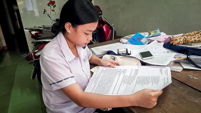 Cô nữ sinh xứ Huế nhận bộ đề thi THPT quốc gia đặc biệt in riêng trên khổ giấy A3. Ảnh: QT