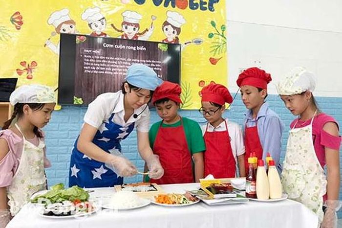 Giáo viên hướng dẫn con công nhân kỹ năng nấu ăn trong dịp hè tại Trường mầm non Đông Phương thuộc Tập đoàn Phong Thái đầu tư vận hành tại xã Bắc Sơn (huyện Trảng Bom)