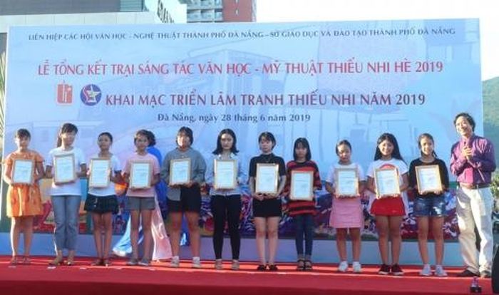 Ban tổ chức trao giải cho các trại sinh có tác phẩm xuất sắc tại Trại văn học - mỹ thuật thiếu nhi năm 2019. (Ảnh: CAND)