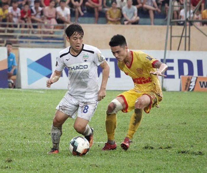Minh Vương (áo trắng) trong một pha đi bóng trước sự kèm cặp của cầu thủ Nam Định. Ảnh: Mai Anh