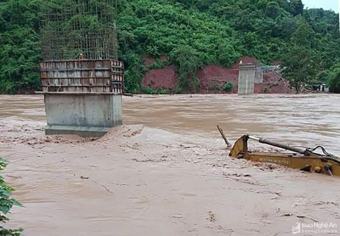 Một máy múc đất đang thi công công trình cầu bản Yên Hòa bị chìm sâu trong nước lũ. Quốc lộ 16 qua xã Mỹ Lý cũng ngập ở đoạn qua bản Xốp Tụ. Ảnh: Lữ Phú