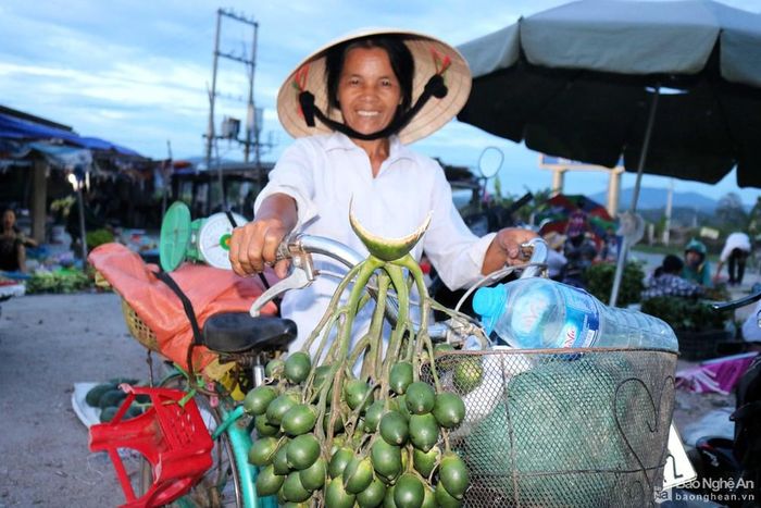 Khi trời chưa sáng rõ, một phụ nữ mang theo những thức quà quê đi chợ sớm.