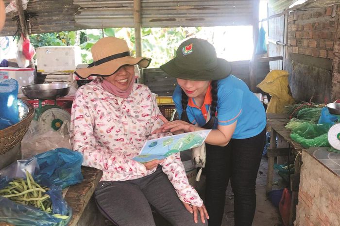 Các chiến sĩ Mùa hè xanh tuyên truyền về kỹ năng phân loại rác tại nguồn cho bà con tiểu thương ở chợ Duy Phước (xã Duy Phước, huyện Duy Xuyên) Ảnh: NVCC