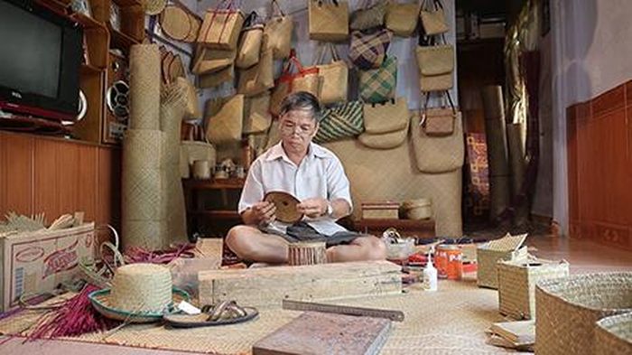 Nghệ nhân Nguyễn Viết Nam với các sản phẩm hiện đại chế tác từ cỏ bàng.