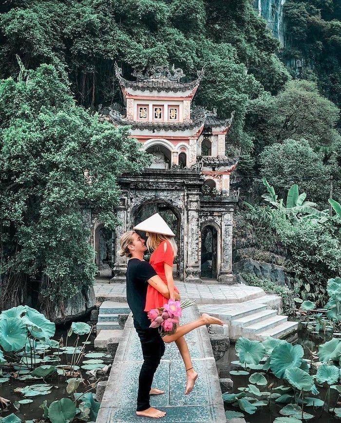 Đi sâu vào bên trong, du khách sẽ đến chiếc cầu đá xanh dẫn vào cổng Tam quan của chùa Bích Động, cổ tự có kiến trúc độc đáo nổi tiếng ở thành phố Ninh Bình. Tọa lạc bên sườn núi Bích Động (hay núi Ngũ Nhạc), xung quanh ngôi chùa cổ cũng là hồ sen thanh tịnh tạo cảnh sắc hữu tình, an yên. Ảnh: Lehatruc, yrana.travel.