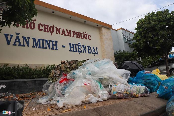  Chợ Nam Phước (huyện Duy Xuyên) nằm sát quốc lộ 1, khoảng hai tuần nay không có người đến thu gom rác, người dân phải tập kết trước cổng chợ. "Chính quyền xã dự kiến đưa rác từ chợ Nam Phước để đến khu vực chôn lấp, giảm thiểu bớt mùi hôi nhưng làm như vậy việc ô nhiễm lại trầm trọng hơn", ông Nguyễn Văn Bảy, nhà gần chợ Nam Phước cho hay. 