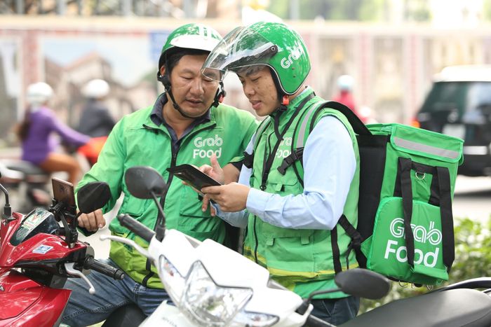 Anh Khiêm (trái) thường trao đổi cùng đồng nghiệp những cập nhật mới của ứng dụng làm việc