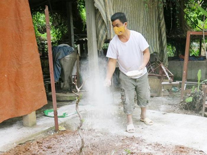 Người dân rắc vôi bột khử trùng khu vực chuồng nuôi.