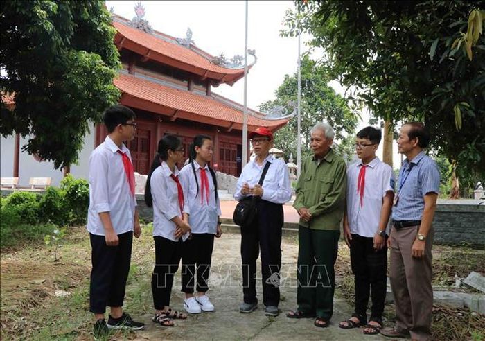 Cựu đội viên Đội Thiếu niên du kích Đình Bảng Nguyễn Đức Thìn (áo trắng) và đội trưởng Nguyễn Thạc Hoàn (áo xanh) giao lưu với các em học sinh trường THCS Đình Bảng, thị xã Từ Sơn, tỉnh Bắc Ninh.