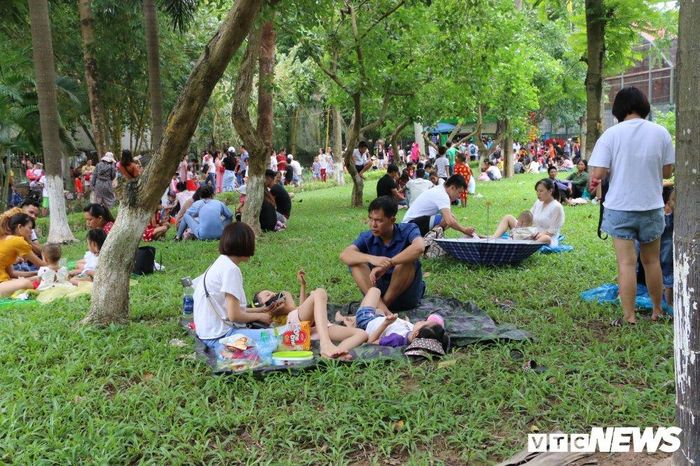  Thời tiết Hà Nội trưa 2/9 nắng nóng và oi bức, nhiều gia đình tụ tập, bày đồ ăn, thức uống la liệt trên các bãi cỏ của công viên. 