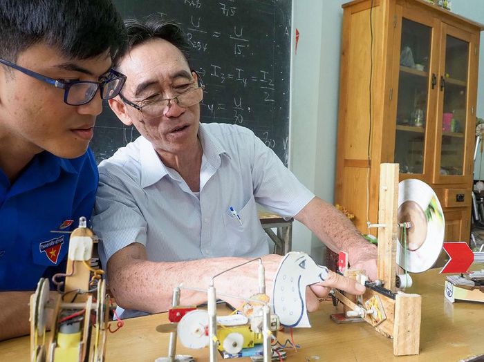 Thầy giáo Ngô Văn Thiệu cùng học sinh say sưa với những sáng kiến. Ảnh: HOÀNG HÙNG