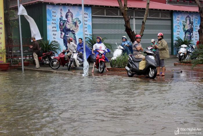 Nước dâng lên cao nên người dân không dám xuống đường lưu thông mà phải chờ nước rút. Ảnh: Quang An