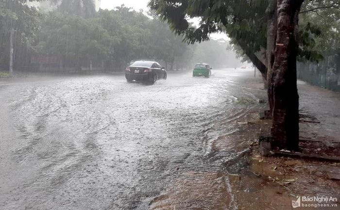 Đường Duy Tân nước tràn lên cả vỉa hè. Ảnh: Quang An