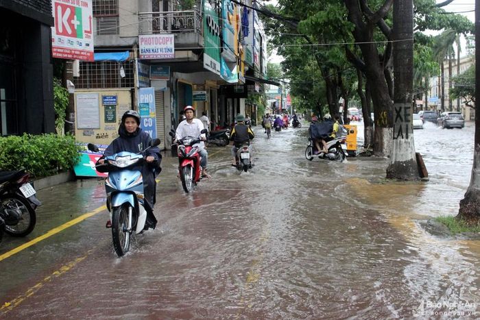 Đường Nguyễn Thị Minh Khai ngập sâu, người dân buộc phải đi trên vỉa hè do lo ngại chết máy. Ảnh: Quang An