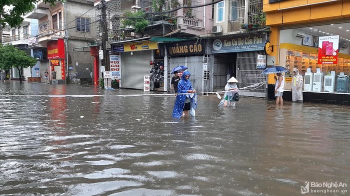 Người dân trên đường Đặng Thái Thân căng dây cảnh báo nguy hiểm do nước ngập sâu. Ảnh: Thành Cường