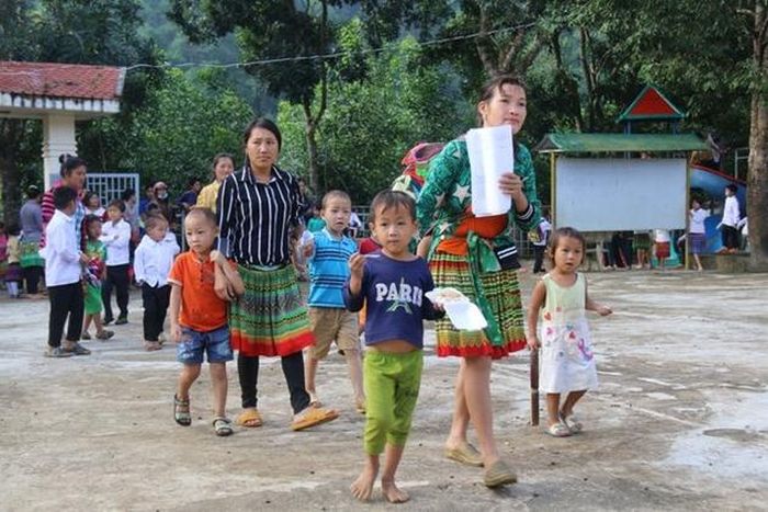 Học sinh đồng bào H'Mông được bố mẹ dẫn đến trường ngày khai giảng