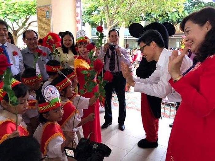 Phó Thủ tướng Vũ Đức Đam vẫy tay chào đón học sinh lớp 1 trường Tiểu học Lê Văn Tám (quận 7, TPHCM).