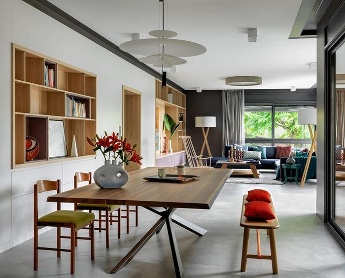 Căn phòng có bộ bàn ăn được kê sát với giá sách. Phía trước là bộ bàn ghế sofa dành cho việc tiếp khách. Nhìn toàn thể nhà ở trông rất thoáng đãng, gọn gàng.