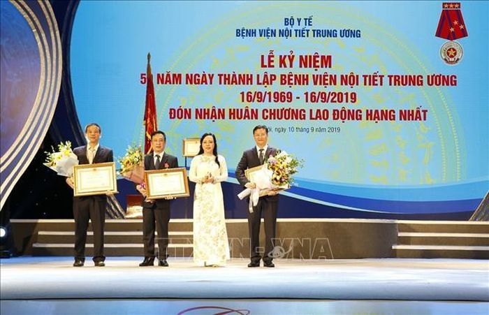 Bộ trưởng Bộ Y tế Nguyễn Thị Kim Tiến, Trưởng ban Ban Bảo vệ sức khỏe cán bộ Trung ương thừa ủy quyền của Chủ tịch nước trao Huân chương Lao động cho 1 tập thể và 2 cá nhân của bệnh viện Nội tiết Trung ương. Ảnh: Dương Ngọc/TTXVN