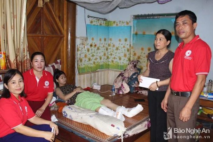 Hội Chữ thập đỏ thị trấn Quỳ Hợp thăm hỏi và trao tiền hỗ trợ cho gia đình em Nguyễn Thoại Ly. Ảnh: Phan Giang