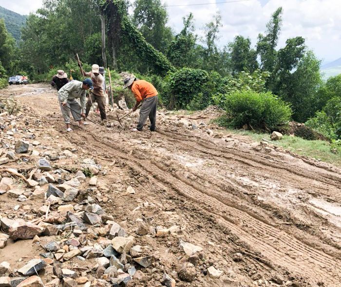 Công nhân hốt dọn đất đá bị tràn ra đường.