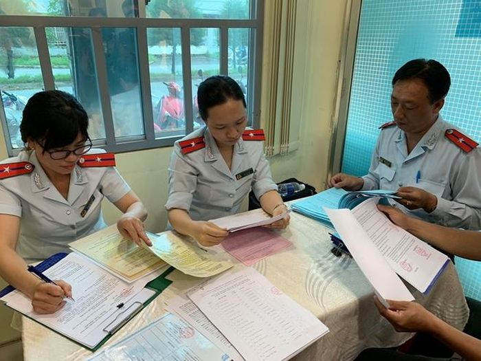 Thanh tra viên kiểm tra hồ sơ nguồn gốc nguyên liệu thực phẩm được mua về tại công ty Khải Thành
