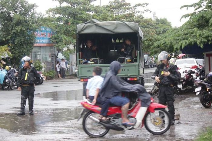 Cơ mưa tầm tã khiến cho đoạn đường bị ngập, người dân được hướng dẫn đi đường tránh