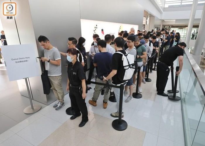 Tuy nhiên, năm nay Apple có một số thay đổi về chính sách. Hãng ưu tiên đặt trước trên website, chuẩn bị số lượng máy đủ đáp ứng nhu cầu, đồng thời số lượng máy mỗi người được mua cũng nhiều hơn. Do đó, cảnh mua đi bán lại không còn tấp nập như trước. Tại cửa hàng Apple ở khu Central, nơi đông nhất cũng chỉ có khoảng 50 người xếp hàng 30 phút trước giờ mở bán, chủ yếu là chờ lấy máy đã đặt trước. Ảnh: Oriental Daily.