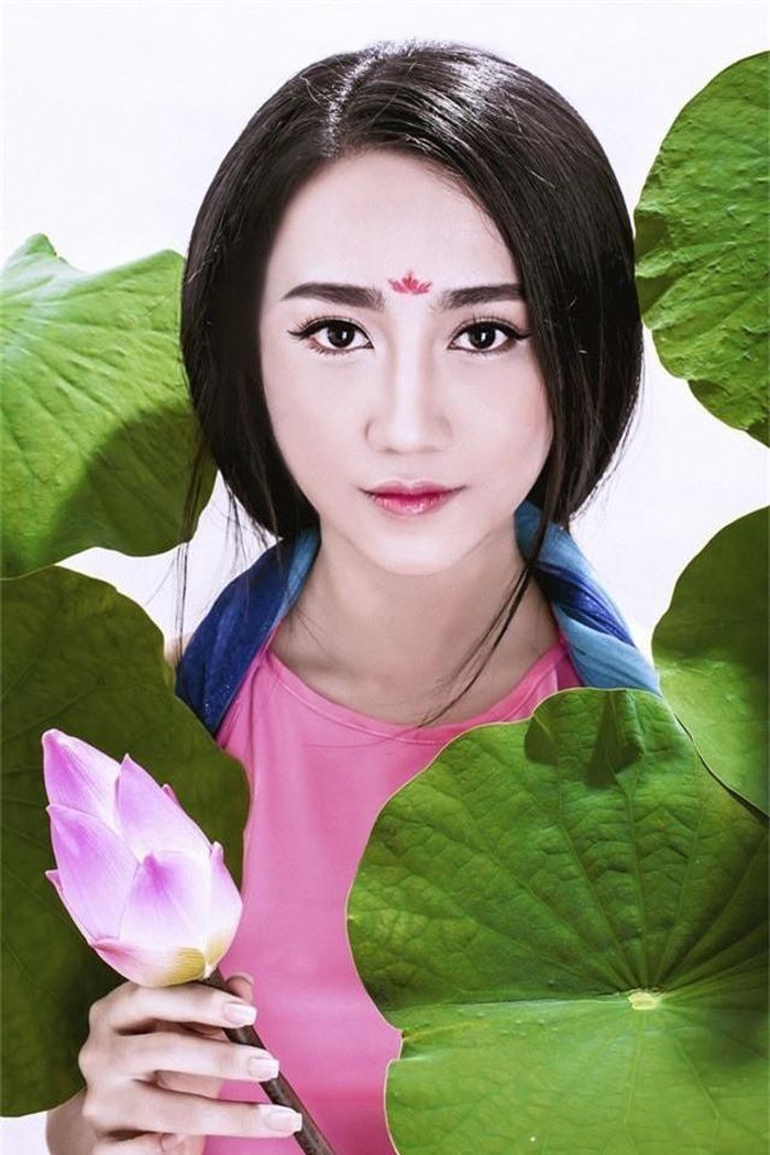  Lona Huỳnh còn đưa hình ảnh hoa sen vào trong bộ ảnh của mình như một dấu ấn về văn hóa truyền thống. Bông sen hồng cùng màu sắc với tấm yếm đào khiến cô hot girl trông rất quyến rũ. 