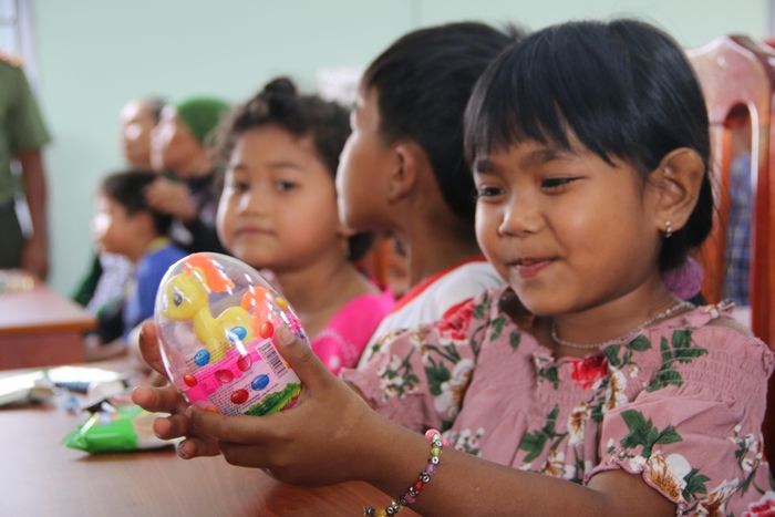 Một em nhỏ vui mừng với món quà vừa được tặng