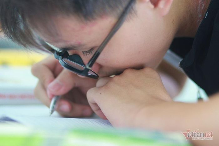 Để viết được, Trung phải cúi rạt người xuống thấp.